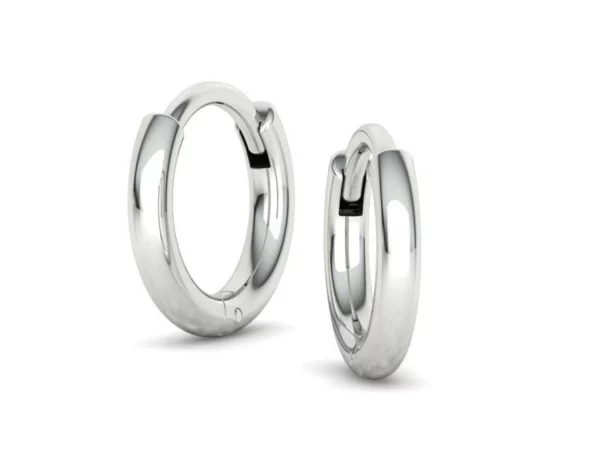 A pair of round, feminine hoop earrings resting on a soft, velvet surface, highlighting their smooth texture and radiant shine, ideal for adding a touch of elegance to any outfit.