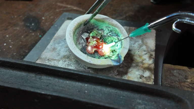 Metal pieces heated with a torch in a ceramic crucible at Bamina’s workbench